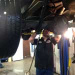 Mechanic working on the rear of a car.